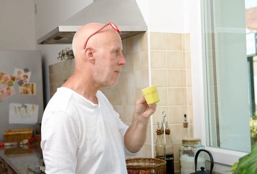 a middle-aged man drinking a cup of coffee