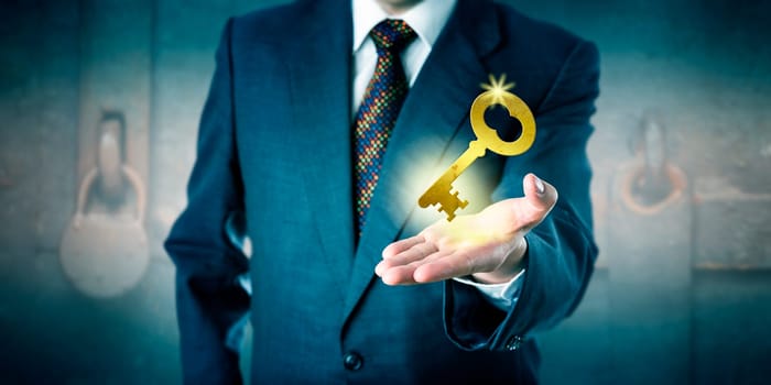 Business man is offering a golden key in his open palm. Business concept for key to success, access to knowledge, secure contract, turnkey solution, corporate secrets, safe investment and leadership.