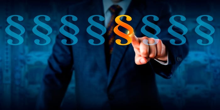 Male compliance and ethics professional is highlighting a paragraph sign in a lineup. Business concept and legal metaphor for regulatory compliance, corporate governance, criminal and civil law.