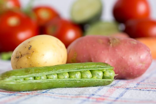 Green beans with potato on a kitchen table with blurred background with other vegetables