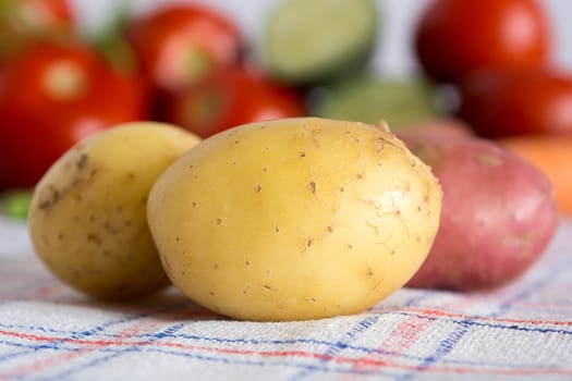 Potatoes on a kitchen table with blurred background with other vegetables
