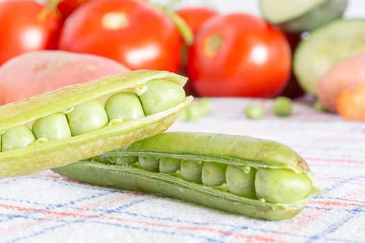 Green beans on a kitchen table with blurred background with other vegetables