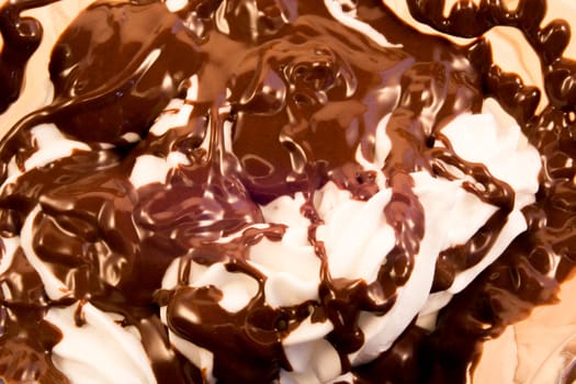 Closeup of glass cup with mixed vanilla and chocolate standing on wooden table