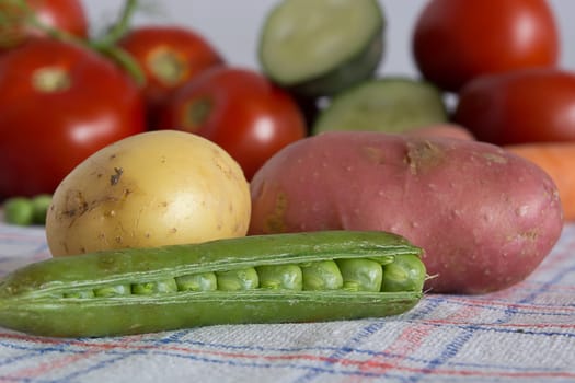 Green beans with potato on a kitchen table with blurred background with other vegetables