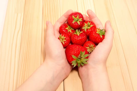 Child hands holding fresh strawberries