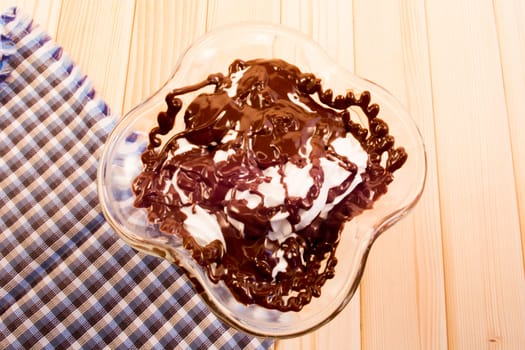 Glass cup with mixed vanilla and chocolate standing on wooden table