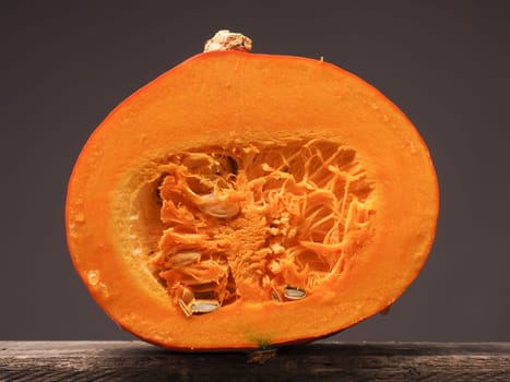Half of a hokkaido pumpkin on a rustic wooden table, healthy food background