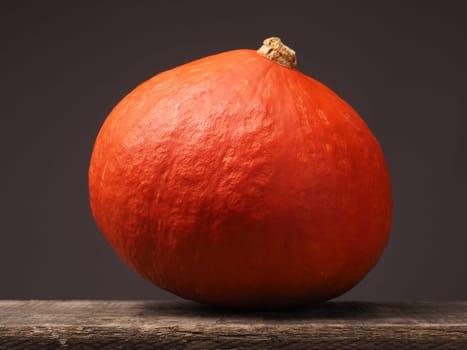 Big hokkaido pumpkin on a rustic wooden table, closeup shot