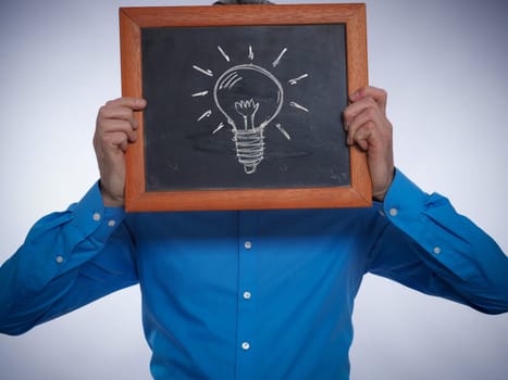 Businessman holding a chalkboard with a hand drawn lightbulb, Great idea concept