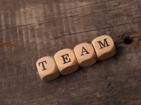 Wooden dices with the word team on a rustic wooden table