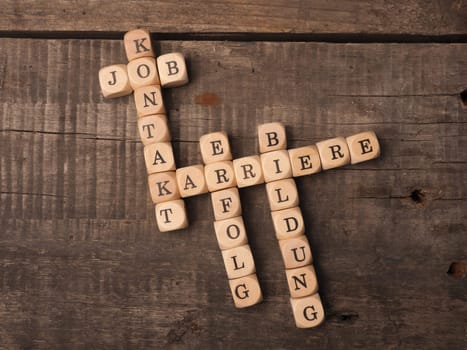 German career concept with the crosswords career, education, job, success and contact on a rustic wooden table