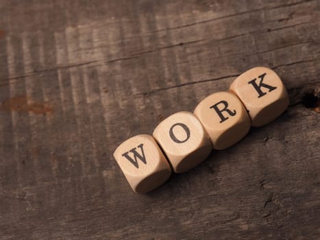 Wooden dices with the word work on a rustic table