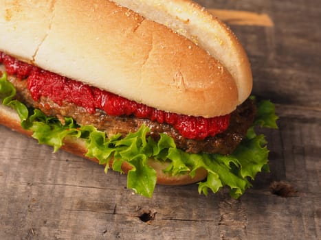 Fresh tasty burger on a rustic wooden table, view from above