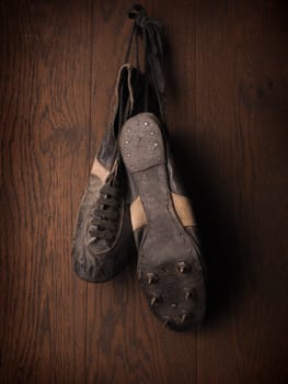 Old sports shoes from 1930 on a rustic wooden wall