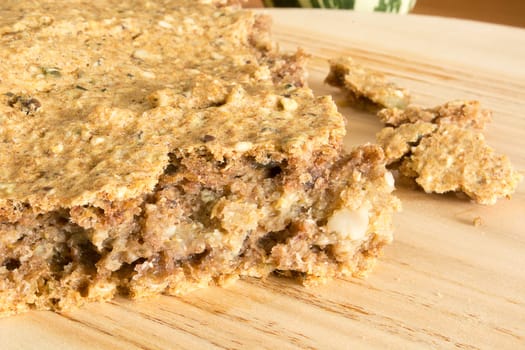 Part of just baked, fresh, domestic unleavened barley bread on the wooden plate