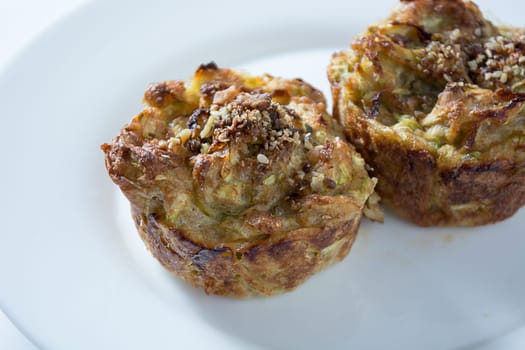 Zucchini muffins in white plate isolated on white background