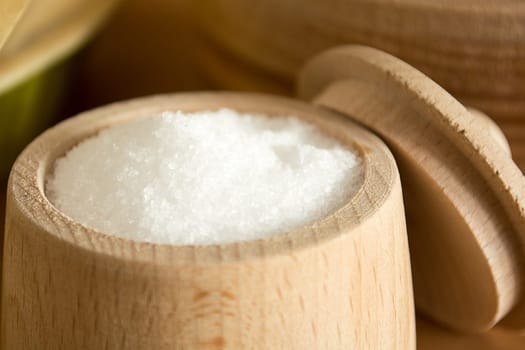 Close up of small wooden cup full of salt sitting on the kitchen table