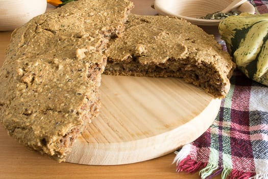 Just baked, fresh, domestic unleavened barley bread on the wooden plate, cutted in half