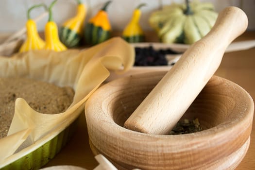 wooden mortar on wooden kitchen table with cracked pumpkin seeds