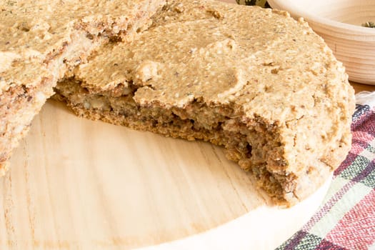 Just baked, fresh, domestic unleavened barley bread on the wooden plate, cutted in half