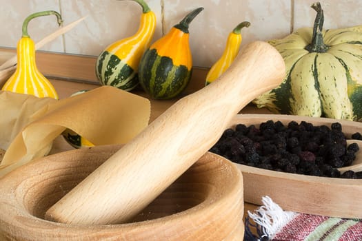 wooden mortar on wooden kitchen table with cracked pumpkin seeds