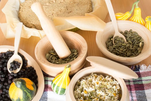 Various seeds and berries in wooden kitchen wares placed on kitchen table