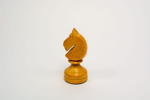 Old wooden chess piece white knight isolated on white background