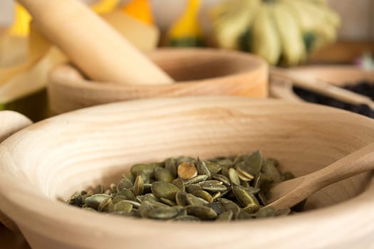 Wooden bowl with pumpkin seeds and wooden spoon in it