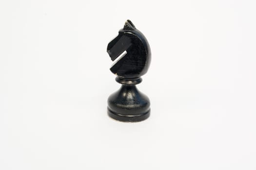 Old wooden chess piece black knight isolated on white background