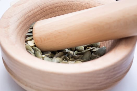 wooden mortar with cracked pumpkin seed