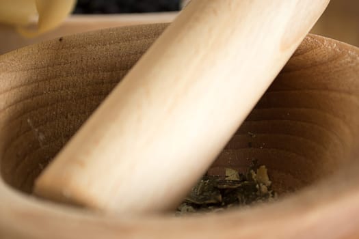 wooden mortar on wooden kitchen table with cracked pumpkin seeds