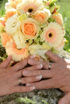Bridal bouquet with hands from the bridal couple & wedding rings