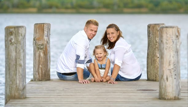 happy young family at the jetty on the lake