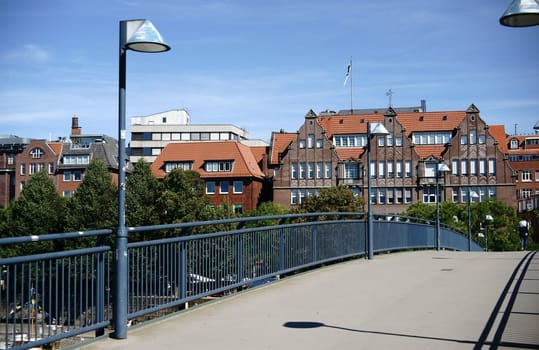 A pedestrian bridge over the Weser with a view of the old town and waterfront.