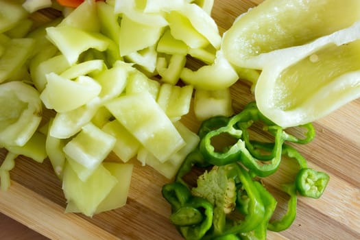 Kitchen full of various vegetables. Pepper, tomatoes sliced and ready to be boiled