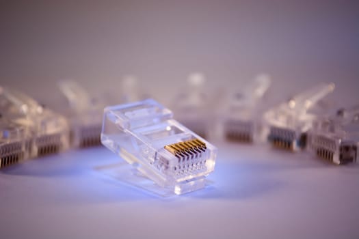 Group of RJ-45 connectors on white background, Connectors are translucent and collored with blue light