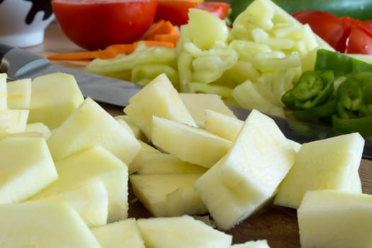 Kitchen full of various vegetables. Pepper, tomatoes sliced and ready to be boiled