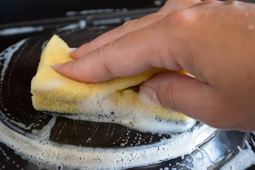 Close up of woman cleaning cooker at home kitchen