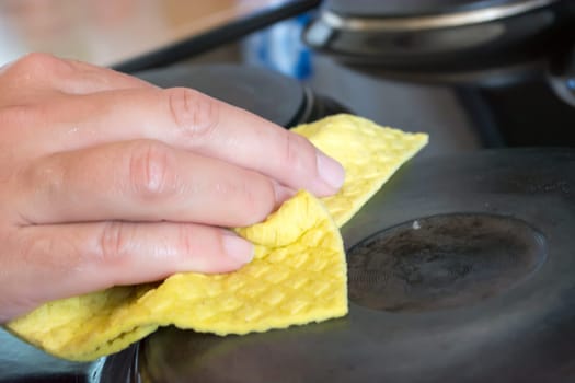 Close up of woman cleaning cooker at home kitchen