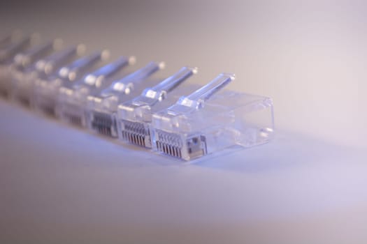 Group of RJ-45 connectors on white background, Connectors are translucent and collored with blue light
