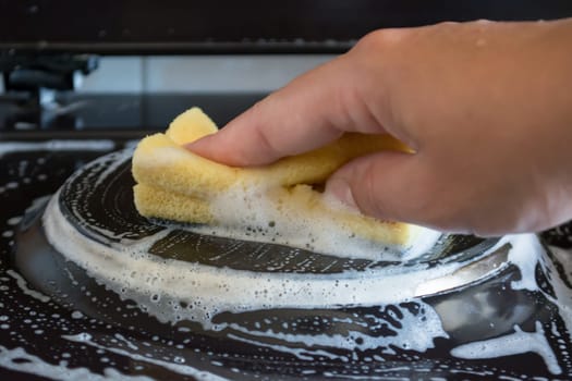 Close up of woman cleaning cooker at home kitchen