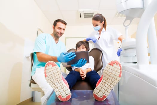 A little girl at the dentist getting a explanation with a Tablet PC..