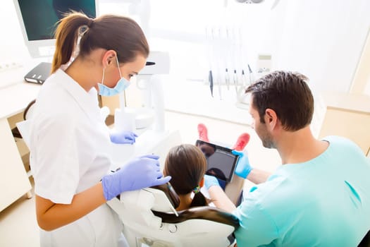 A little girl at the dentist getting a explanation with a Tablet PC..