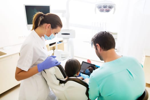 A little girl at the dentist getting a explanation with a Tablet PC..