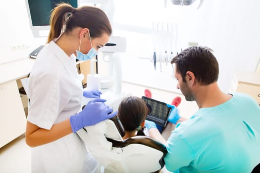A little girl at the dentist getting a explanation with a Tablet PC..