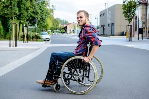 young disabled man in wheelchair on road
