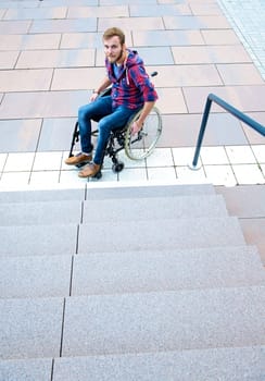 young disabled man in wheelchair under stairs