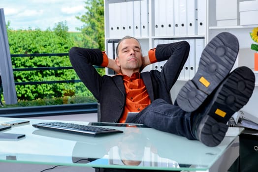 young business man at his desk is relaxing