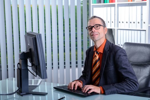 young business man at his desk looking friendly
