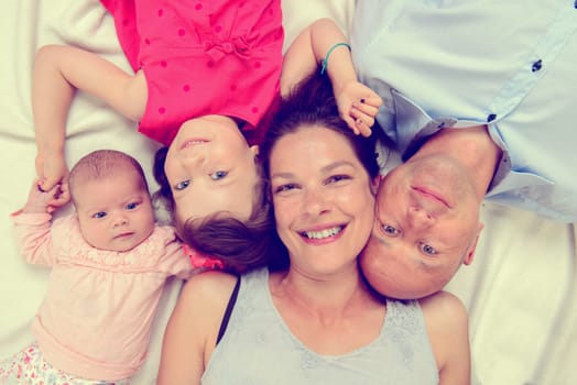 young happy family lying on floor- from top